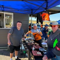 Members gathered around the barbecue at a club event